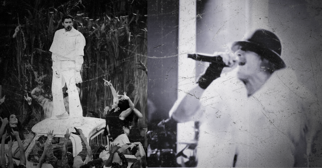 Two individuals on stage with a crowd in a black and white setting