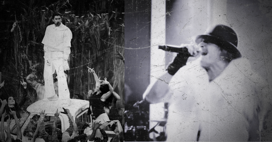 Two individuals on stage with a crowd in a black and white setting