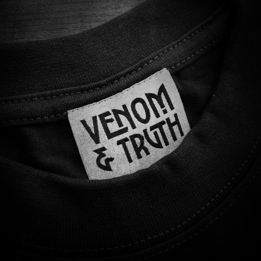 Close-up of a black shirt with 'Venom & Truth' label.
